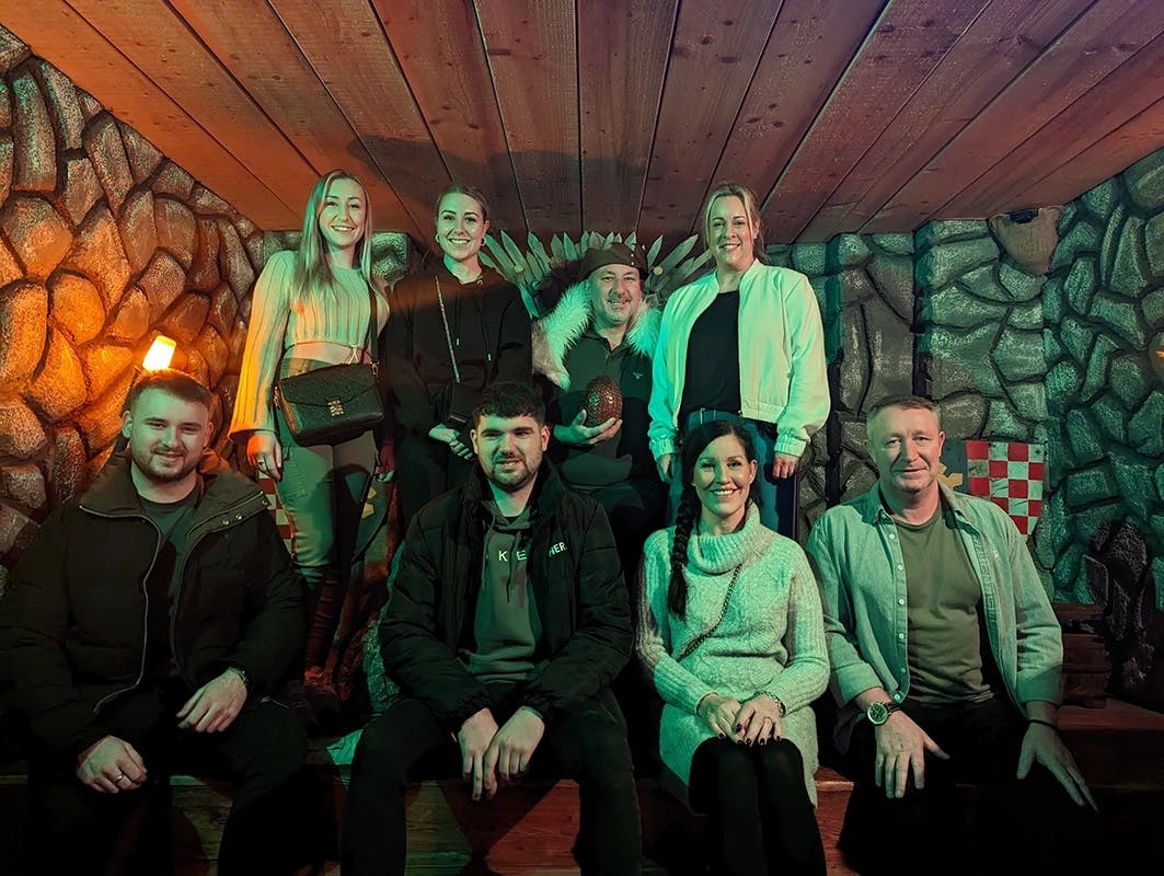 An adult group of people are sitting and standing together in a happy mood after enjoying a day of fun activities at Incognito Escape Rooms in Dublin, Ireland